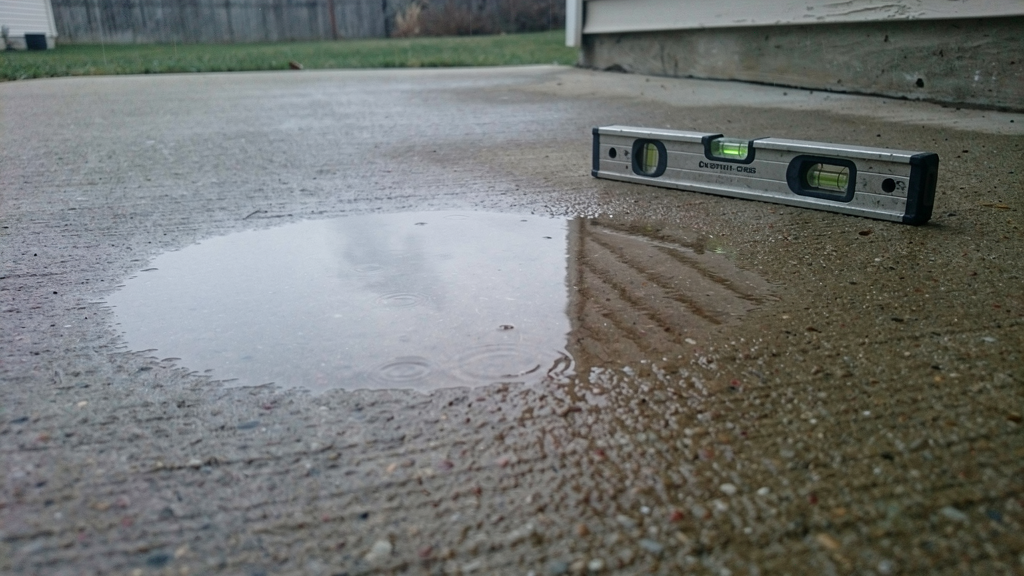 Rainwater collecting in a low area of a concrete patio